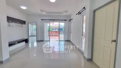Spacious modern living room with large windows and glossy tiled floors