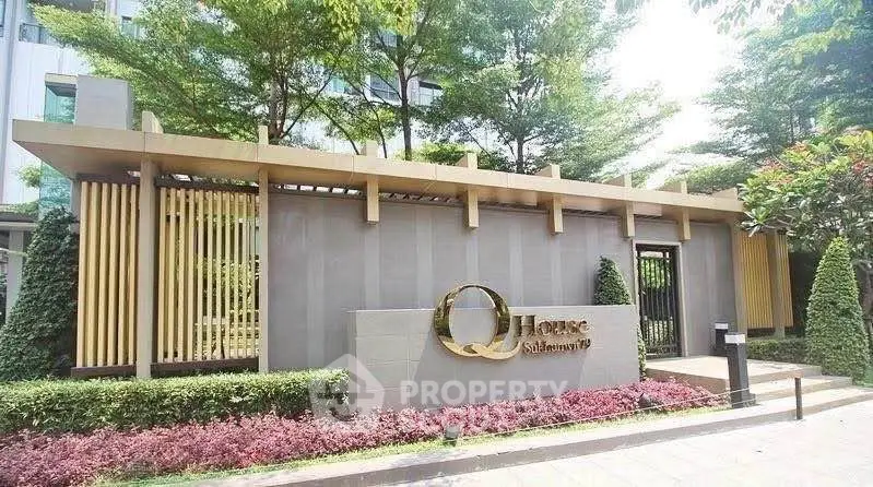 Modern building entrance with lush landscaping and stylish architectural design.