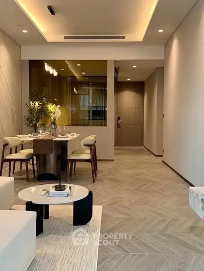 Elegant modern living room with dining area, featuring stylish furniture and warm lighting.