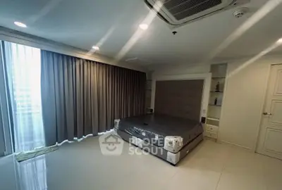 Spacious bedroom with modern design and large windows for natural light.