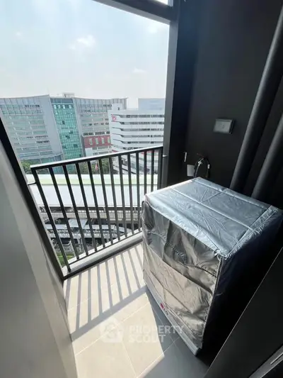 Modern balcony with city view and covered appliance, ideal for urban living.