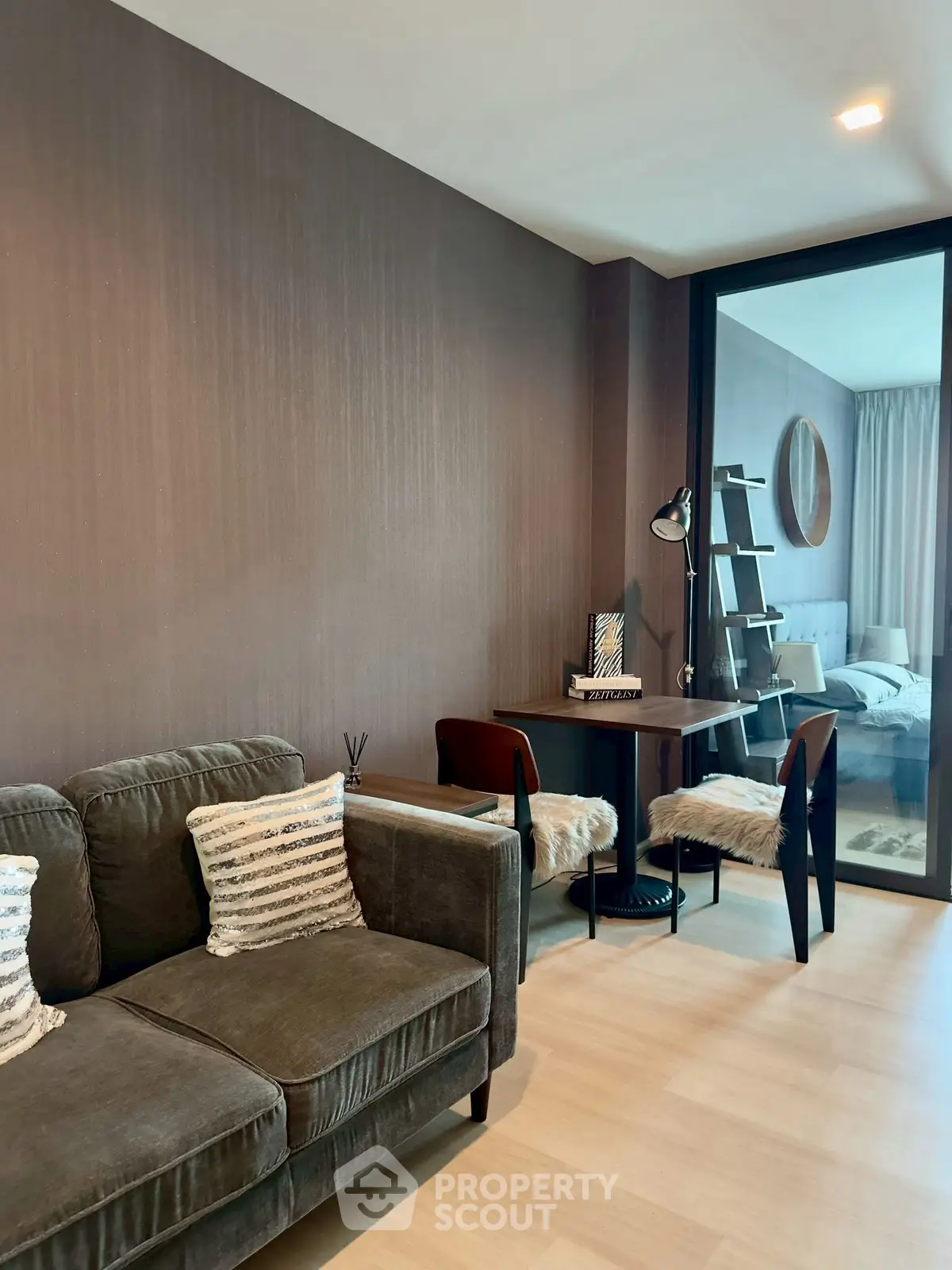 Modern living room with cozy seating and stylish decor adjacent to a bedroom.