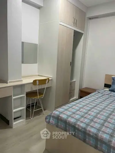 Cozy bedroom with built-in wardrobe and study desk, perfect for modern living.