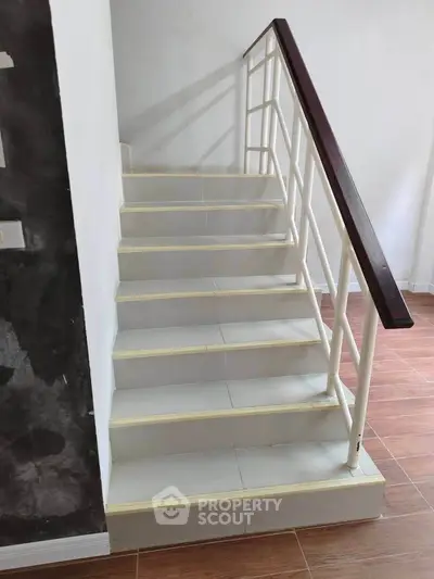 Modern staircase with sleek railing and wooden steps in a contemporary home interior.