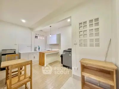 Modern kitchen with open layout and wooden furniture, featuring sleek appliances and ample natural light.