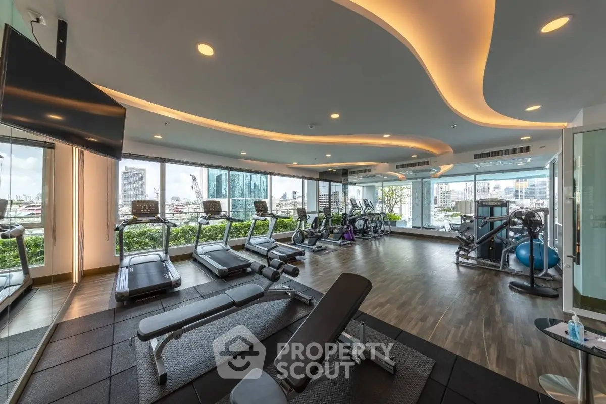 Luxurious gym with modern equipment and stunning city views in high-rise building.