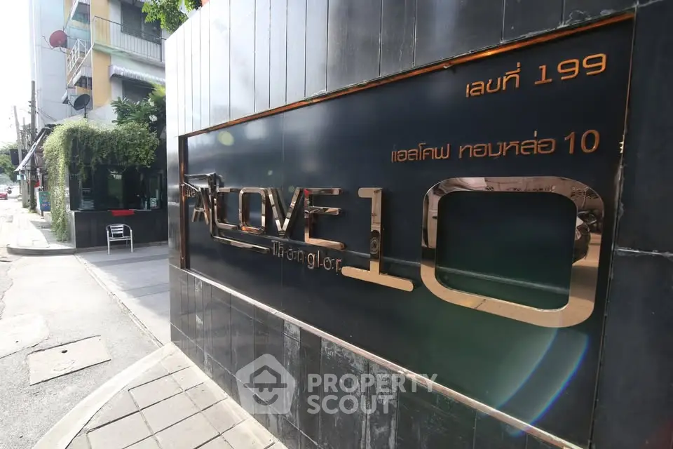 Modern urban building entrance with sleek signage and street view