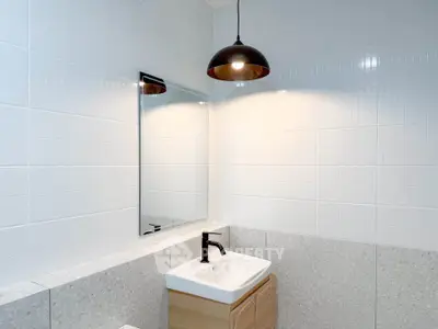 Modern bathroom with sleek sink and stylish lighting in a contemporary home.