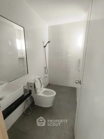 Modern minimalist bathroom with sleek fixtures and white tile design.