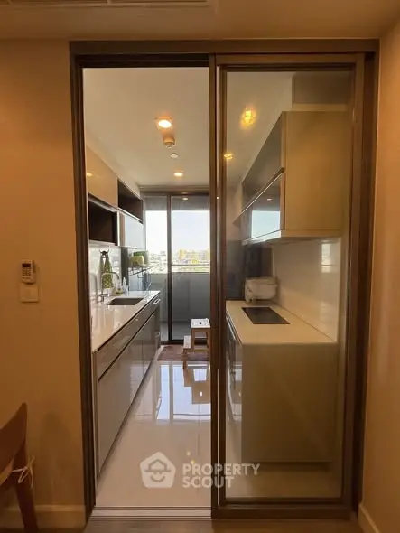 Modern kitchen with sleek design and city view, featuring closed layout and ample natural light.