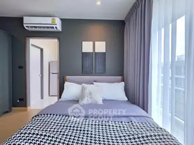 Modern bedroom with stylish decor and large window for natural light