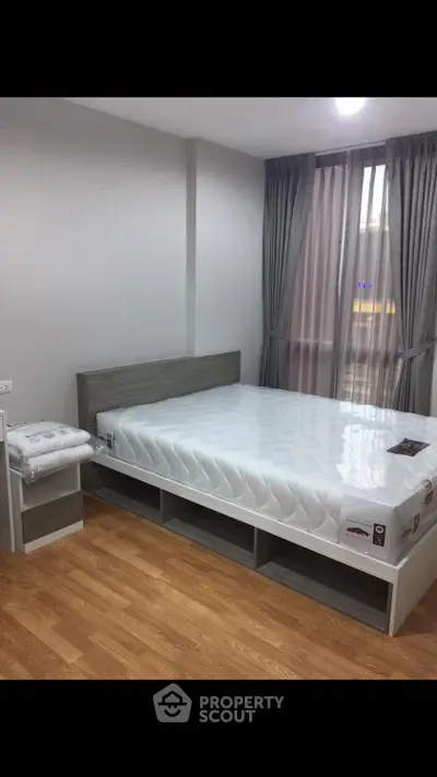 Modern bedroom with sleek wooden flooring and stylish bed frame, perfect for urban living.