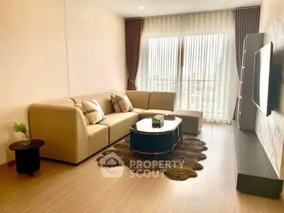 Spacious living room with modern decor and large window for natural light.