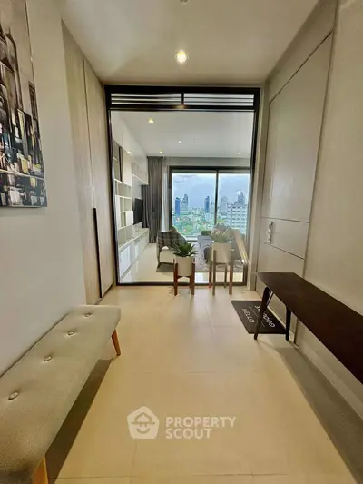 Modern living room with city view, stylish decor, and natural light in high-rise apartment.