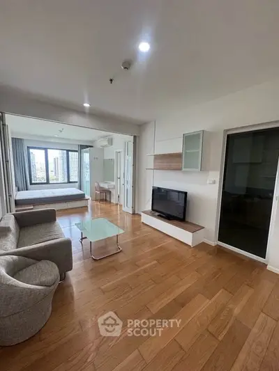 Spacious modern living room with wooden flooring and stylish furniture in a high-rise apartment.