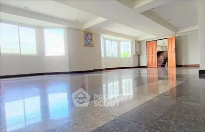 Spacious interior with large windows and polished floors, ideal for versatile living or office space.