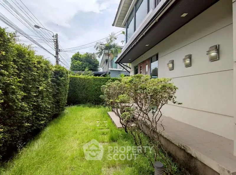 Charming suburban home with lush green garden and modern exterior lighting.
