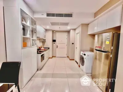 Modern kitchen with sleek cabinetry and high-end appliances, featuring a gas stove, oven, and a convenient washing machine.