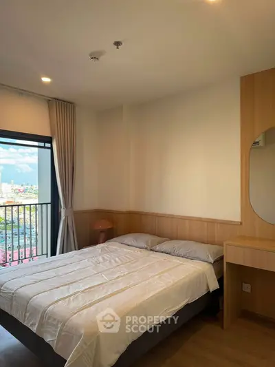 Cozy bedroom with city view and modern furnishings in a high-rise apartment.