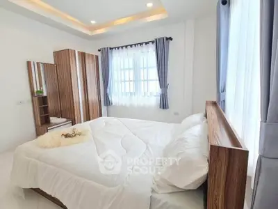 Bright and cozy bedroom with modern wooden furniture and large windows.