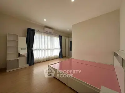 Spacious bedroom with large window and modern furnishings