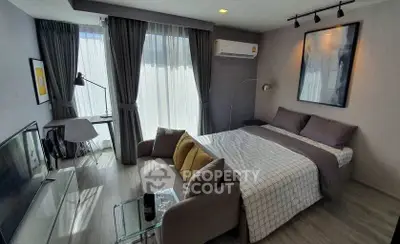 Modern studio apartment with cozy bed, stylish decor, and natural light.