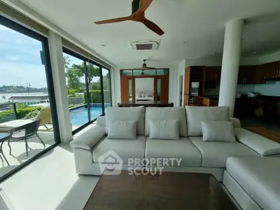 Luxurious open-plan living room with pool view and modern furnishings in a high-end property.