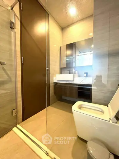 Modern bathroom with glass shower and sleek fixtures in a contemporary apartment.