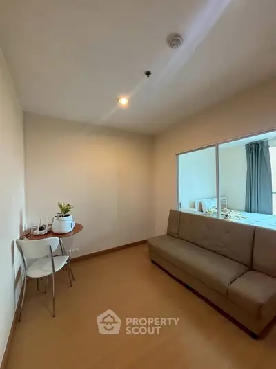 Cozy living room with modern sofa and dining area, perfect for relaxation and entertaining.