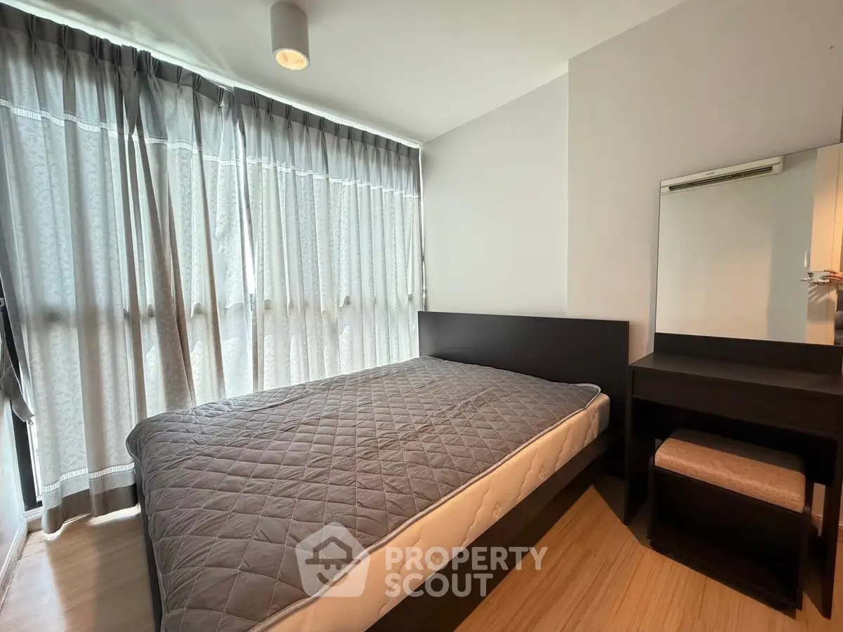 Spacious bedroom with natural light and modern furnishings in a stylish apartment.