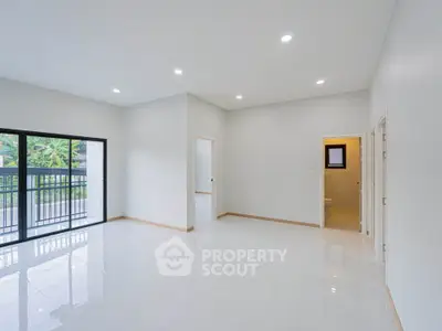 Spacious modern living room with large windows and balcony access, perfect for natural light lovers.