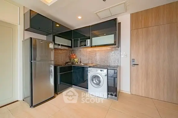 Modern kitchen with sleek appliances and stylish cabinetry in a contemporary apartment.