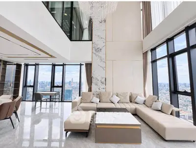 Luxurious high-rise living room with panoramic city views and elegant modern decor.