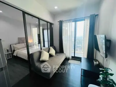 Modern studio apartment with glass partition, cozy living area, and balcony view.