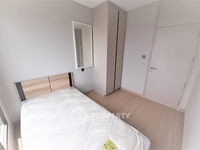 Modern minimalist bedroom with wooden flooring and sleek wardrobe design.
