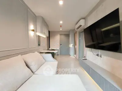 Modern living room with sleek design, large TV, and comfortable seating in a stylish apartment.