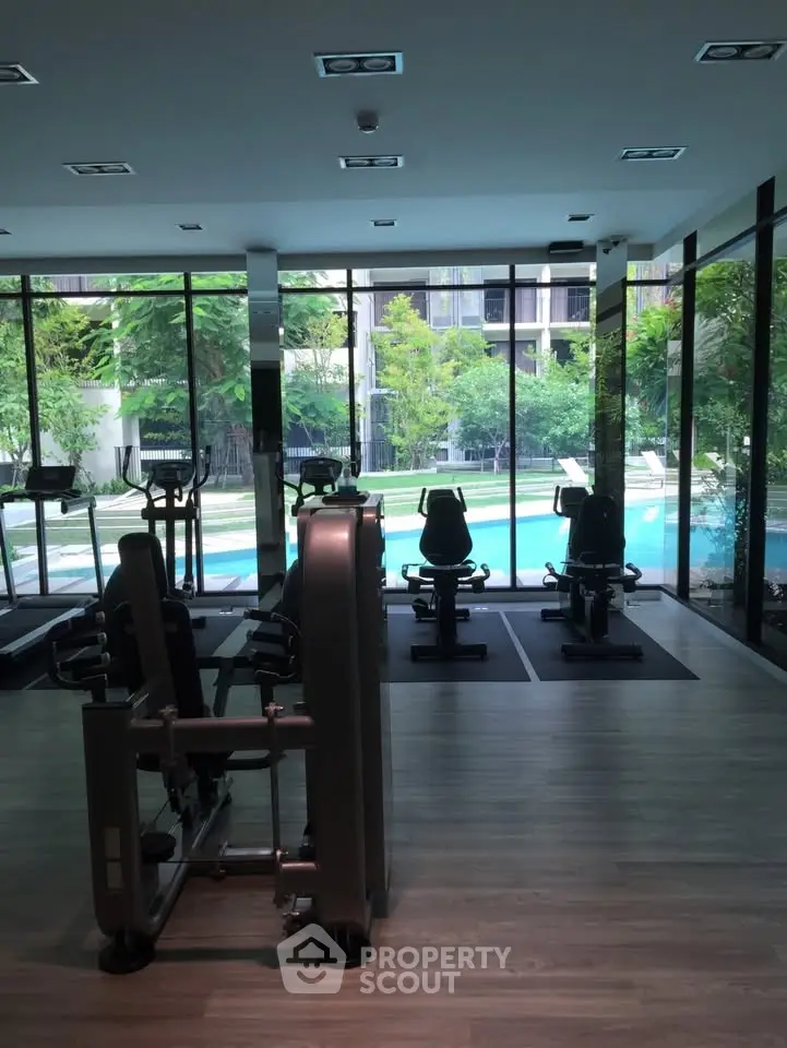 Modern gym with pool view in luxury residential complex