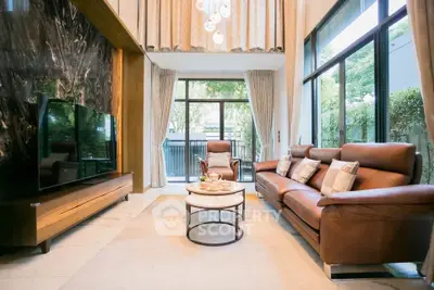 Luxurious living room with high ceilings and elegant decor, featuring large windows and stylish furniture.