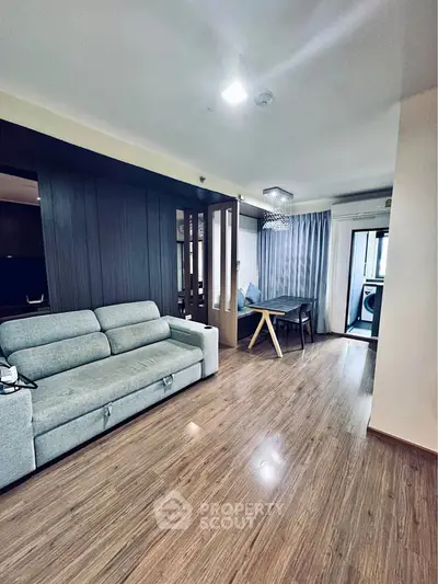 Modern living room with sleek wooden flooring and stylish furniture in a contemporary apartment.