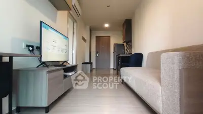 Modern living room with sleek furniture and wall-mounted TV in a stylish apartment.
