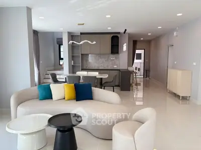 Modern open-plan living room with stylish furniture and sleek kitchen design.