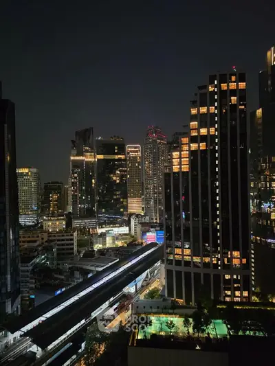 Stunning night view of a vibrant city skyline with illuminated skyscrapers and bustling streets.