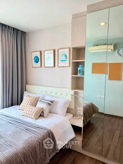Modern bedroom with stylish decor, mirrored wardrobe, and cozy bedding in a contemporary apartment.