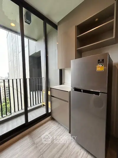 Modern kitchen with sleek fridge and balcony view in urban apartment