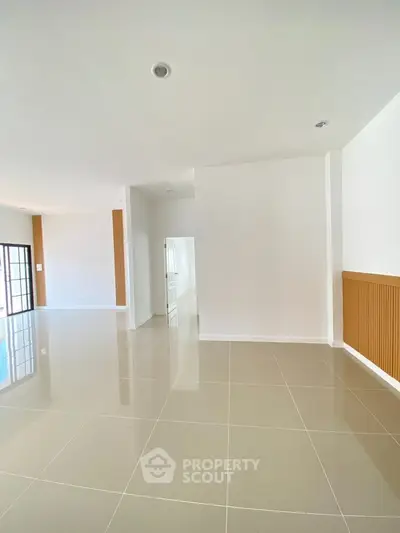 Spacious modern living room with glossy tiled floors and minimalist design.