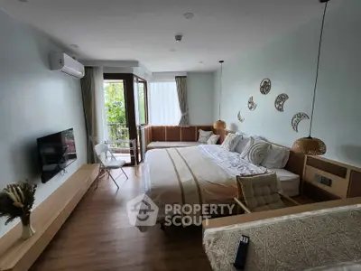 Spacious bedroom with modern decor and balcony access, featuring a large bed and wall-mounted TV.