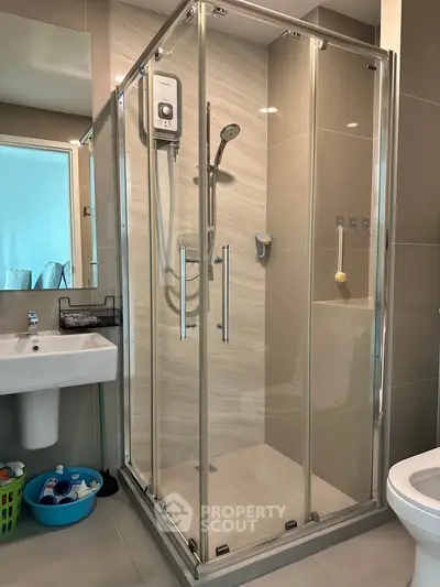 Modern bathroom with glass shower enclosure and sleek fixtures