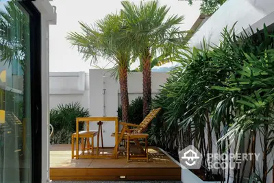 Charming tropical balcony with lush greenery and cozy seating area