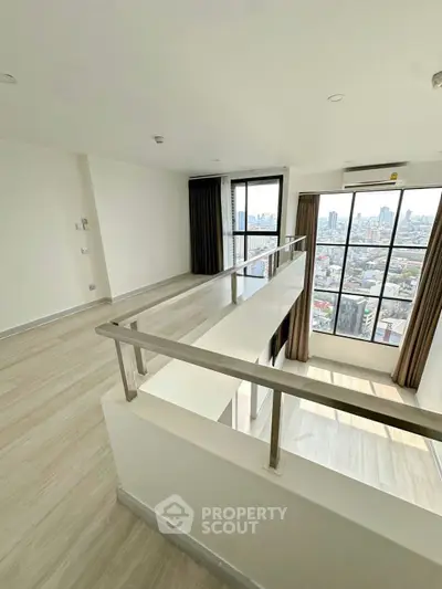 Spacious modern apartment with large windows offering stunning city views, featuring sleek flooring and contemporary design.