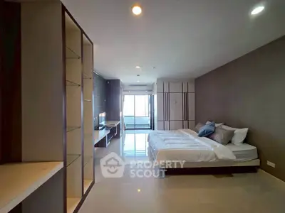 Spacious modern bedroom with sleek design and natural light, featuring a cozy bed and stylish decor.